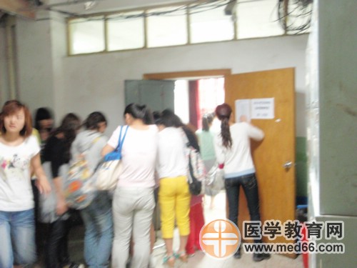 監(jiān)考老師正在查驗衛(wèi)生資格考生的準(zhǔn)考證及證件