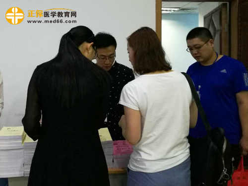 醫(yī)學(xué)教育網(wǎng)工作人員為網(wǎng)校學(xué)員進行教材分發(fā) 