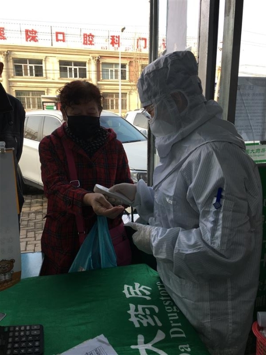 趙海霞為進(jìn)店顧客測量體溫。